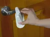 A hand is shown operating a white lock device on a door handle. Náhled obrázku produktu