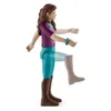 A toy figurine of a girl in riding attire, shown in a side profile with one leg raised. Voir les images du produit