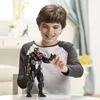 A young boy is playing with a Venom action figure. Produktbild-Vorschau