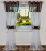 A pair of brown and white sheer curtains hanging in a window.