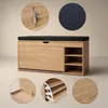 A shoe cabinet with a cushioned seat and pull-out shelves, presented on a plain background with close-up detail shots. Produktbild-Vorschau