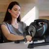 A woman is using a mini exercise bike at a desk. Náhľad obrázku produktu
