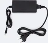 A black power adapter with two cables, one with a European plug and the other with a barrel connector, laid out on a white background. Produktbild-Vorschau