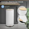 A white cylindrical trash can with a bamboo lid and pedal, shown in a kitchen-like setting with gray cabinets and a plant. Podgląd zdjęcia produktu