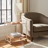 A white and pink bar cart with books and a lamp on it, next to a brown armchair. Anteprima dell’immagine prodotto