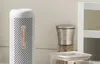 A white dehumidifier sits on a countertop next to a spice grinder and a food storage container. Voir les images du produit