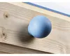 Close-up of a light blue spherical knob attached to a wooden surface with visible wood grain and knots. Produktbild-Vorschau