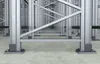 A close-up view of the base of industrial shelving units, showing the metal support structure and concrete floor. Náhľad obrázku produktu