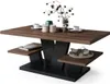 A modern coffee table with a wood-effect top and black base, decorated with a vase of branches and some decorative items. Produktbild-Vorschau