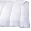 A close-up view of a white duvet with visible stitching and a small label. Produktbild-Vorschau