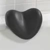 A black heart-shaped bath pillow resting on the edge of a bathtub. Podgląd zdjęcia produktu