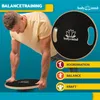 A man is using a balance board, with text and icons highlighting its benefits. Voir les images du produit