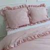 A close-up view of a pink bedding set with ruffled edges. Náhled obrázku produktu