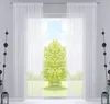 A room interior with a large window covered by sheer white curtains, revealing a view of a green tree and a grassy field under a blue sky. Produktbild-Vorschau