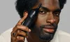 A close-up shot of a man holding a black grooming device near his eye. Produktbild-Vorschau