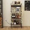 A multi-tiered shelf unit with various items, including bottles, coffee maker, and decorative lights, set up in a home or bar-like environment. Voir les images du produit