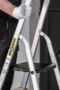 A person wearing gloves is holding a step ladder. Náhled obrázku produktu
