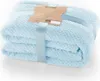 A folded light blue blanket with a tag and ribbon. Podgląd zdjęcia produktu