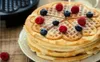 A stack of heart-shaped waffles topped with raspberries and blueberries, placed on a wooden surface. Podgląd zdjęcia produktu