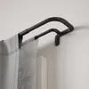 A close-up view of a black double curtain rod mounted on a white wall, with gray curtains hanging from it. Náhled obrázku produktu