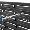 A close-up view of a black pegboard with a screwdriver and a brush being used to clean a hole. Produktbild-Vorschau