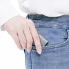 A hand is placing a small gray adapter into the pocket of blue jeans. Náhľad obrázku produktu