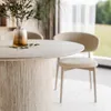 A dining table with chairs in a well-lit room with a view of greenery outside. Produktbild-Vorschau