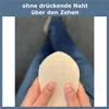 A person is holding a beige sock, showing the toe seam. Produktbild-Vorschau