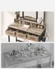 A makeup vanity with drawers and a mirror, and another image of a cluttered vanity tabletop with various beauty products. Náhľad obrázku produktu