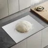 A round of dough is placed on a stainless steel cutting board on a kitchen counter. Náhled obrázku produktu