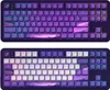 Two identical keyboards are displayed side-by-side against a black background. The keyboards have a dark purple base with keys that feature a gradient of purple, pink, and blue colors. Some keys have a celestial landscape design. Produktbild-Vorschau