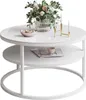 A white round coffee table with a glass top, featuring a floral arrangement, a bowl of candies, a magazine, a cup, and candle holders. Produktbild-Vorschau