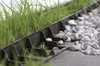 A close-up view of a black plastic edging system separating grass from a gravel path. Náhľad obrázku produktu