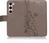 A gray flip phone case with a floral and butterfly embossed design is shown against a white background. Produktbild-Vorschau