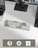 A keyboard is placed on a white desk next to two laptops, with a monitor in the background. Produktbild-Vorschau
