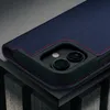 A close-up view of a dark blue iPhone case with red stitching, showing the camera cutout. Voir les images du produit