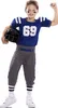 A young boy dressed in a football uniform, holding a helmet and posing with his fist raised. Produktbild-Vorschau