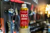 A can of diesel system cleaner additive sits on a stand in front of a wall of tools. Produktbild-Vorschau