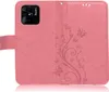 A pink flip case for a smartphone, with a floral and butterfly embossed pattern. Produktbild-Vorschau