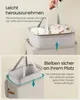 Two images showing a laundry basket with removable inner bags. The top image shows a hand lifting an inner bag out of the basket. The bottom image shows an inner bag being placed into the basket. Produktbild-Vorschau