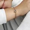 A close-up shot of a person's arm wearing a rose gold bracelet with a heart-shaped charm that says "Love You Sister". Podgląd zdjęcia produktu