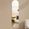 A long, narrow, arched mirror is mounted on a light brown wall, reflecting a living room scene with a sofa, rug, and coffee table. Produktbild-Vorschau