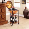 A globe bar cart with wine bottles and glasses, placed in a room with wooden furniture and decorative vases. Anteprima dell’immagine prodotto