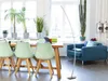 A modern living room with a dining table, chairs, and a blue armchair. Náhled obrázku produktu