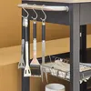 Close-up of barbecue tools hanging from a rack on a grill. Produktbild-Vorschau