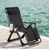 A black reclining chair is placed on a white surface next to a body of water. Produktbild-Vorschau