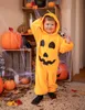 A child in a pumpkin costume stands in front of a Halloween-themed display. Produktbild-Vorschau
