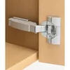 A close-up shot of a cabinet hinge attached to a wooden cabinet. Produktbild-Vorschau