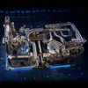 A complex mechanical model with gears, tubes, and a spinning component, illuminated by blue LED lights. Podgląd zdjęcia produktu