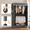 A portable wardrobe with clothes hanging inside and on shelves, shown with detail shots of its wheels and adjustable feet. Voir les images du produit